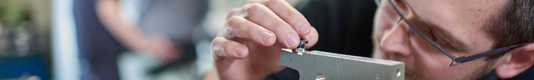 QSQ Mitarbeiter bei der präzisen Einstellung einer Vorrichtung.